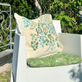White chair with decorative pillows in a garden setting